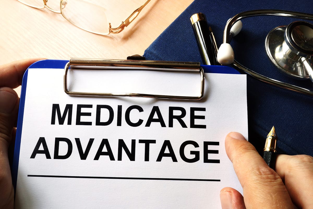 A person holding up a sign that says medicare advantage.