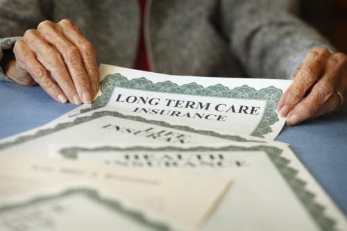 A person is holding papers that are on top of each other.