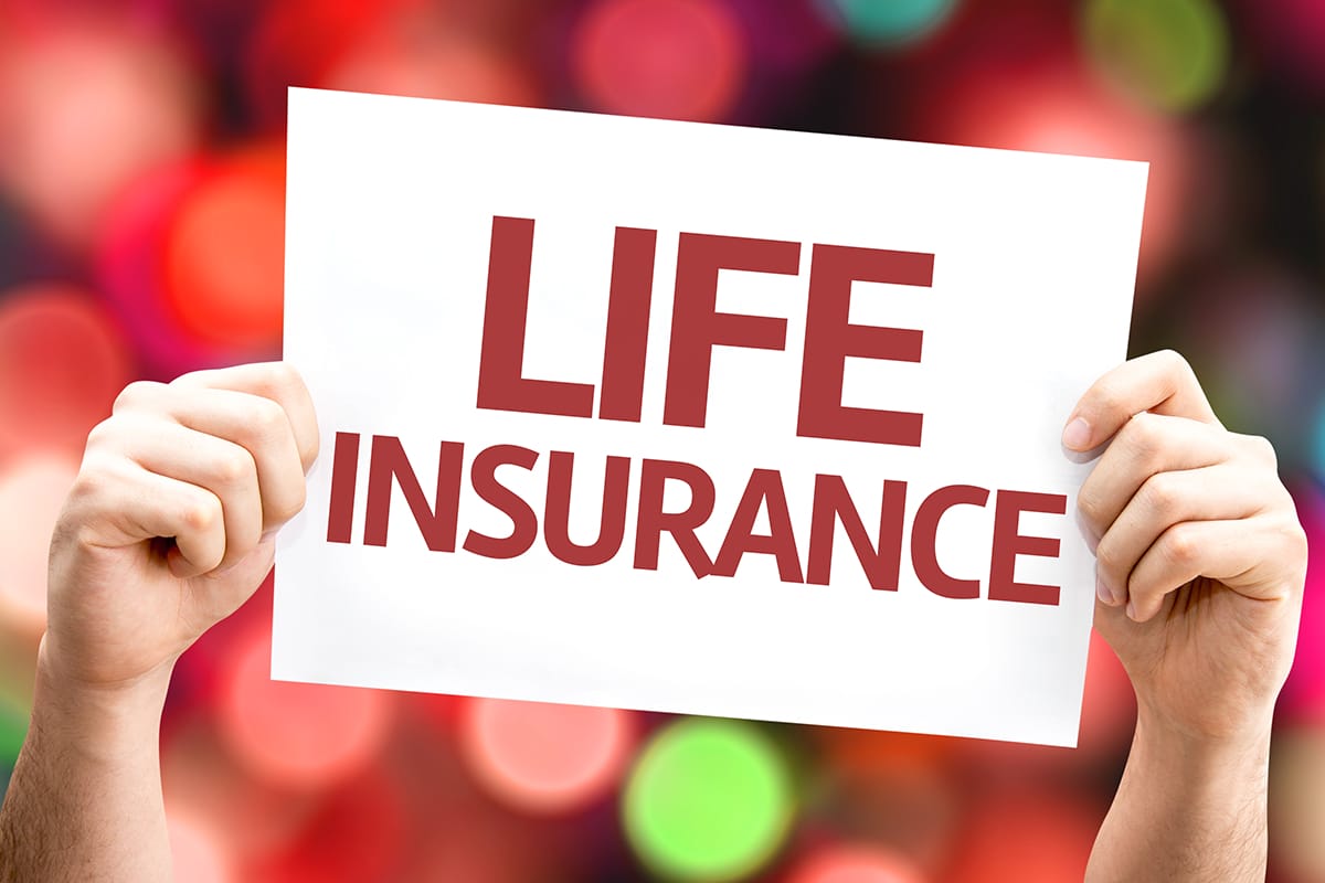 1 A person holding up a sign that says life insurance.